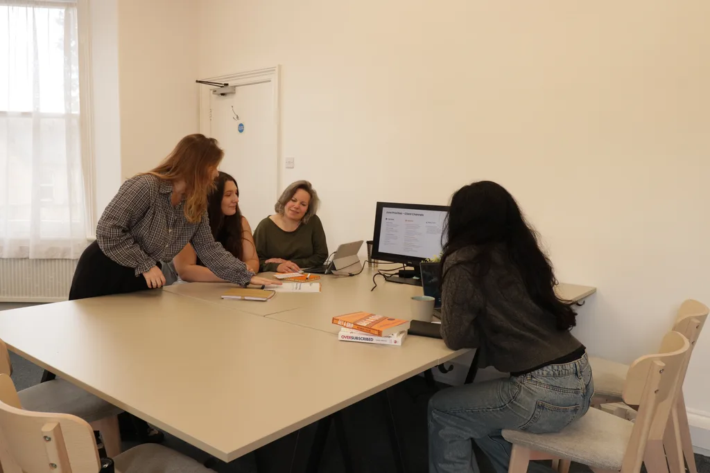 Four team members discussing their work around an office table