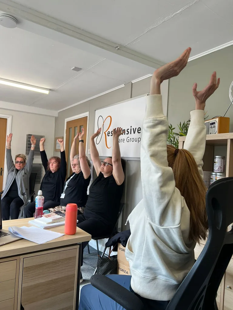 An EverFit instructor leading a group through seated overhead reaches